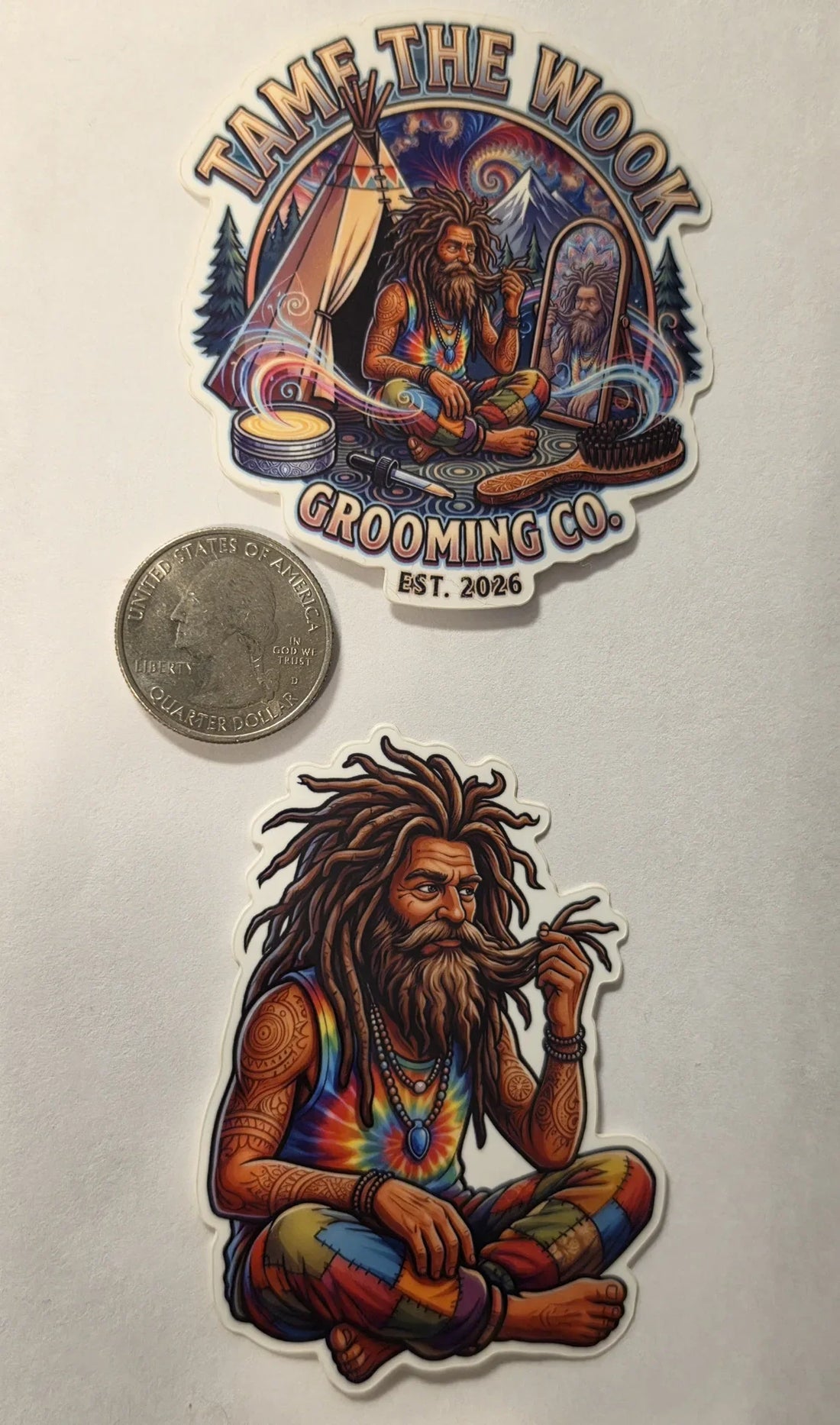 Both Tame the Wook stickers next to a US quarter for scale