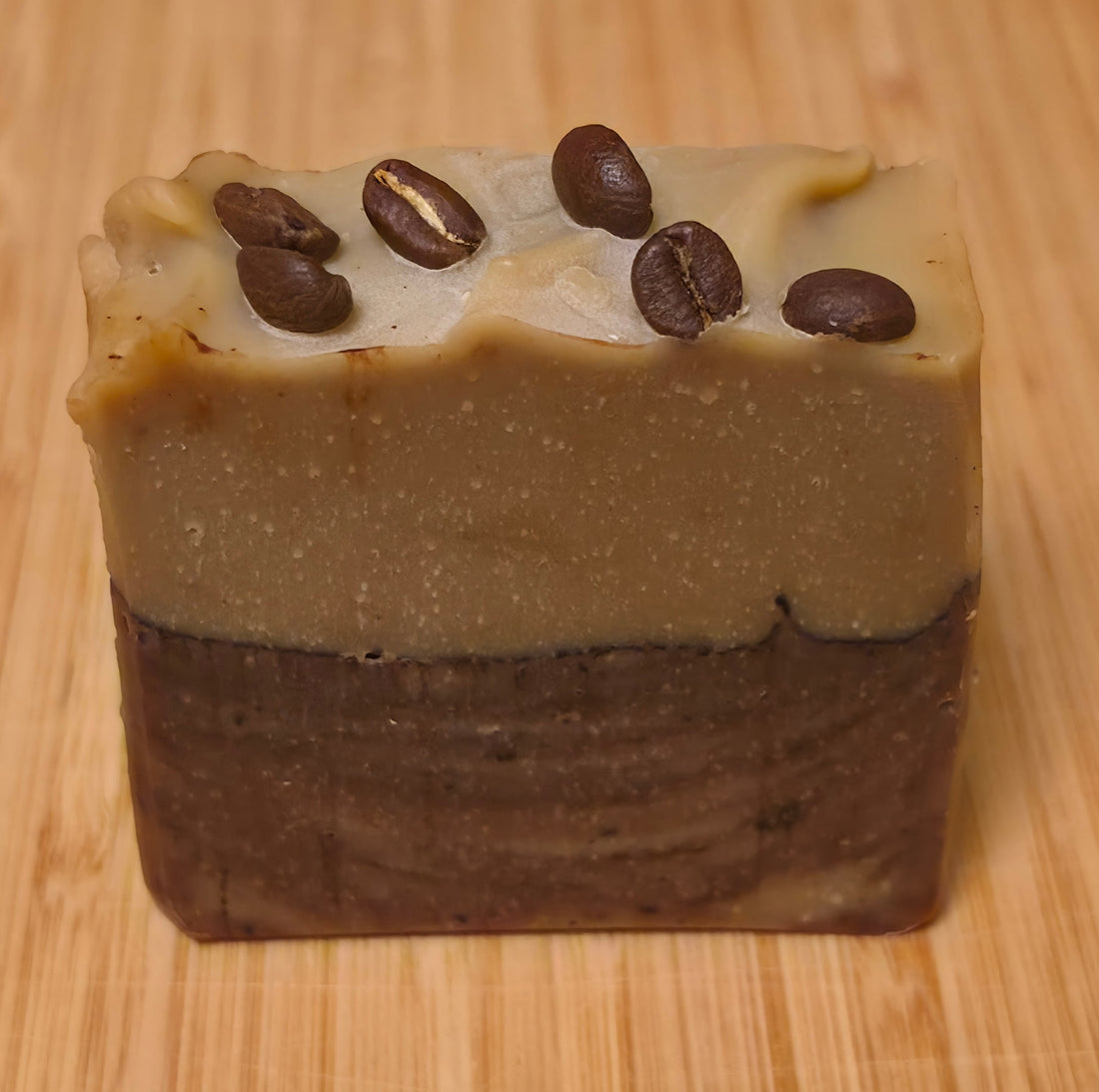 Wook-Away Brewed Awakening soap bar on a wooden board, topped with whole coffee beans
