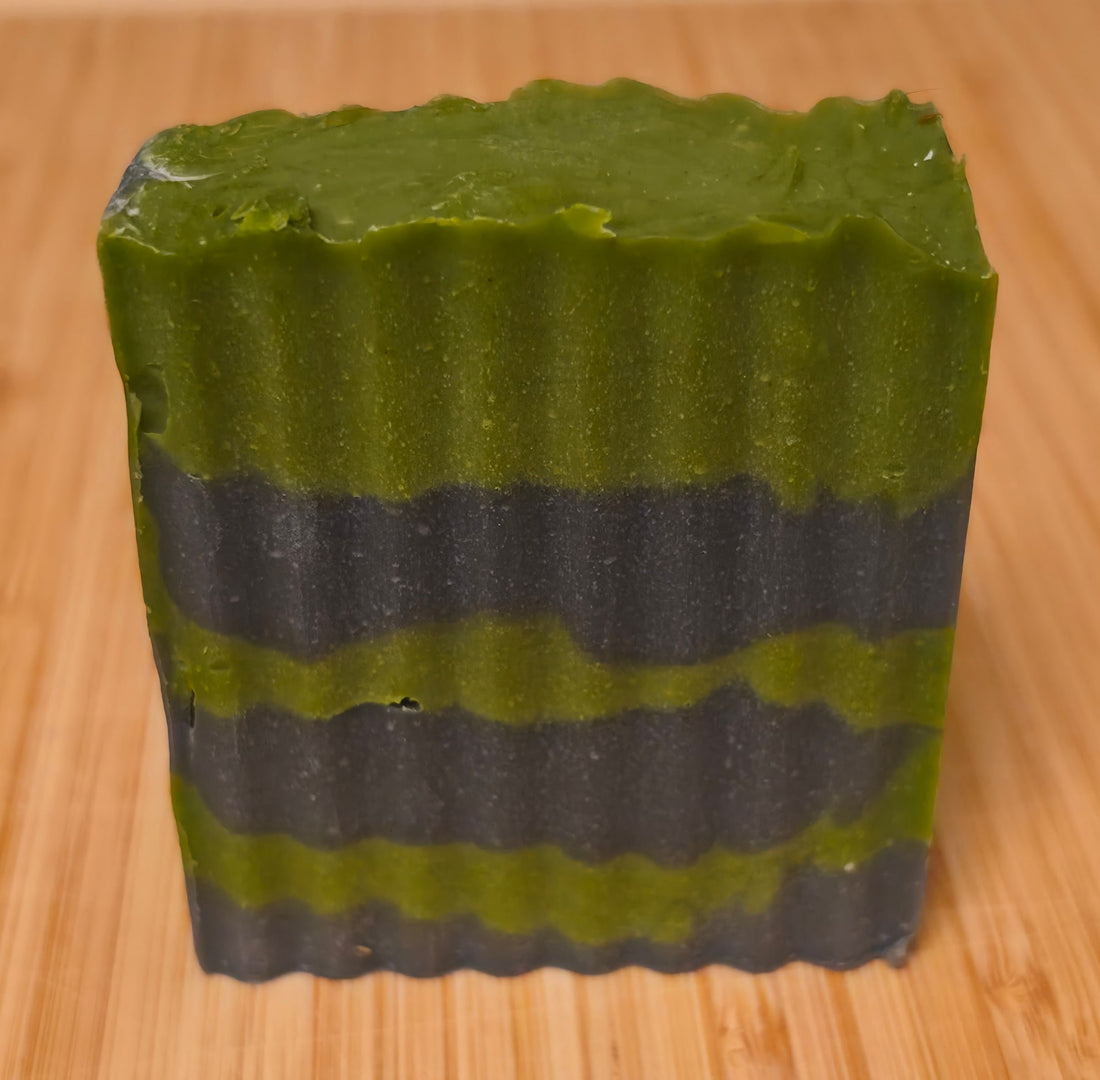 Wook-Away Tree Hugger soap bar on a wooden board, green and near-black layers